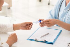 Medical professional handing card to patient
