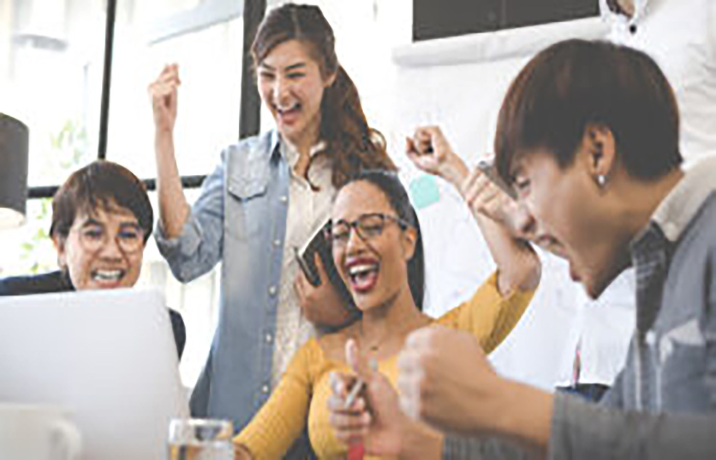 People cheering in front of a computer